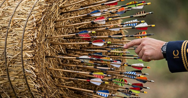 Close-up of arrows stuck in a cylindrical straw teer target after a shooting round