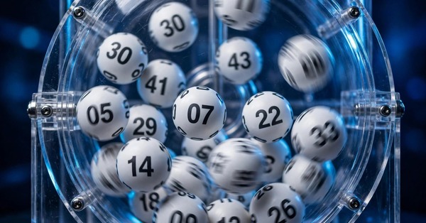 Lottery balls tumbling inside a transparent draw machine during a random number draw
